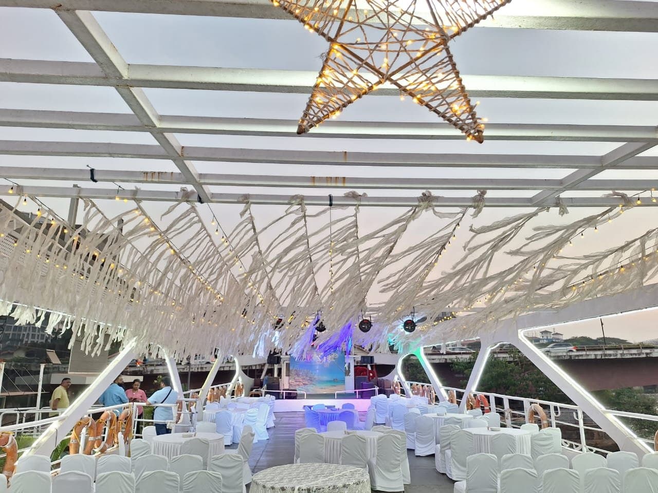 Princesa's upper deck dressed for an event at dusk on the Mandovi River